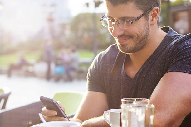 istock Young man  at cafe with smart phone 517283463