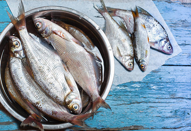 istock fresh fish in  iron bowl on a wooden background 517286007