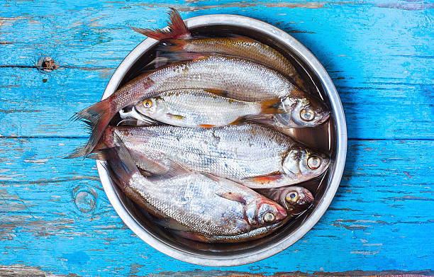 istock fresh fish in  iron bowl on a wooden background 517286055