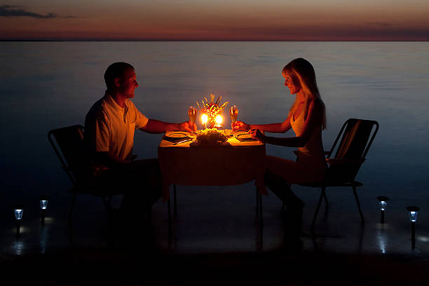 istock young couple share romantic dinner with candles on the beach 517286555