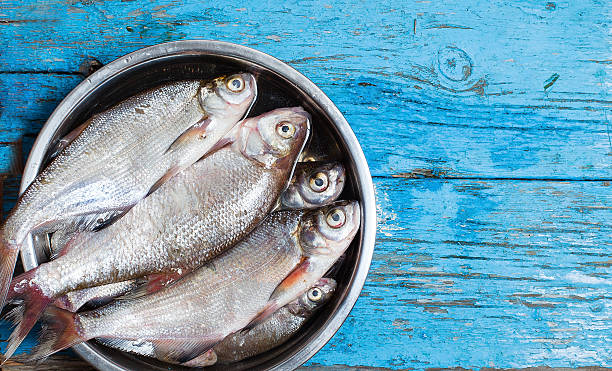 istock fresh fish in  iron bowl on a wooden background 517286687