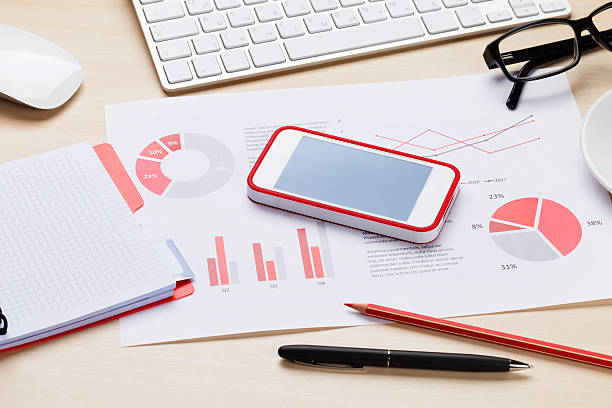 istock Office desk workplace with phone, charts and coffee 517300232