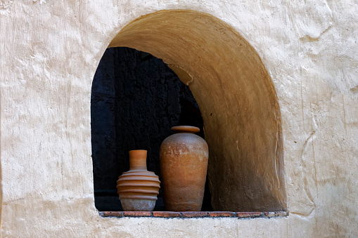 Two terracotta vases in an alcove set in to a whitewashed wall