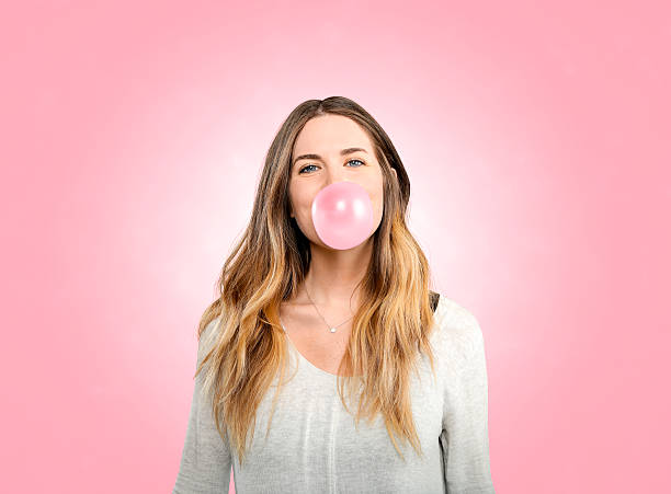 istock Pretty woman blowing pink bubble 517302764