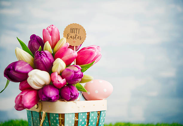 istock Tulip bouquet with Easter eggs and Easter basket in grass 517304850