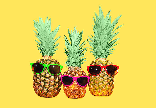 istock Three pineapple with sunglasses on yellow background, colorful ananas photo 517307812