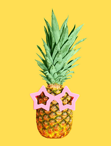 istock Pineapple with sunglasses on yellow background, colorful ananas 517308060