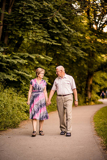 istock Senior couple walking in park 517309616