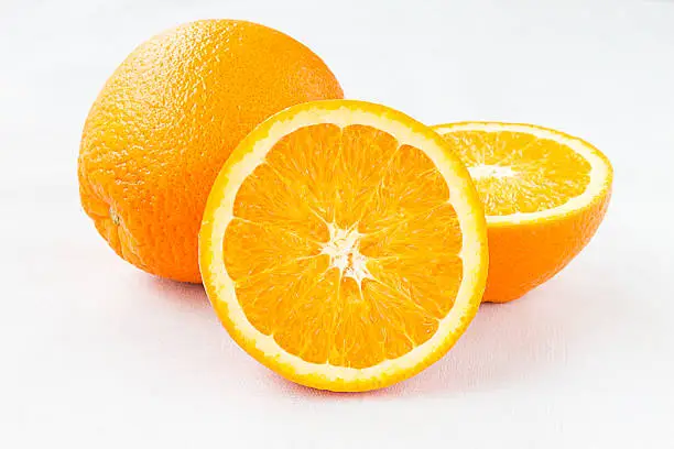 Navel orange seedless Fruites on white Tablecloth, Fresh juicy Organic orange with a second fruit at the apex visible