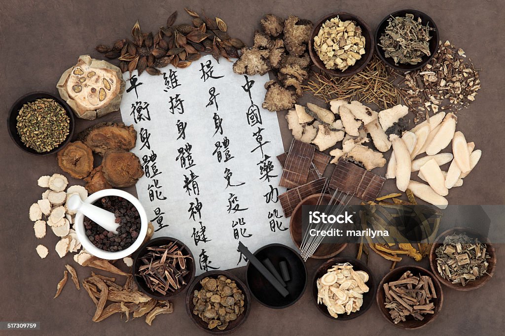 Chinese Alternative Medicine Chinese herbal medicine selection, acupuncture needles, moxa sticks and mandarin calligraphy script. Translation describes chinese herbal medicine as increasing the bodys ability to maintain body and spirit health and balance energy. Acupuncture Stock Photo