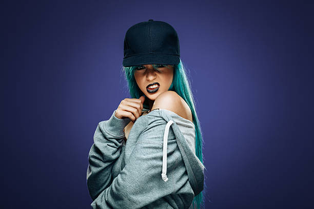 Sexy hip hop woman in hoodie and cap stock photo