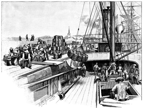 A cargo ship loading or unloading barrels beside a quay. From “The Cottager and Artisan: The People’s Own Paper” illustrated by various artists and published by The Religious Tract Society, London, in 1896.