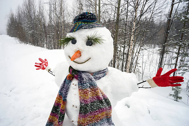 istock Funny smiling snowman standing in the woods 517311468