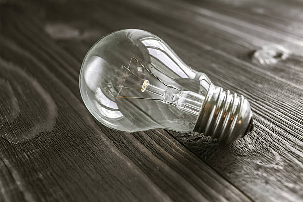 istock incandescent lamp on the wooden rustic background 517311808