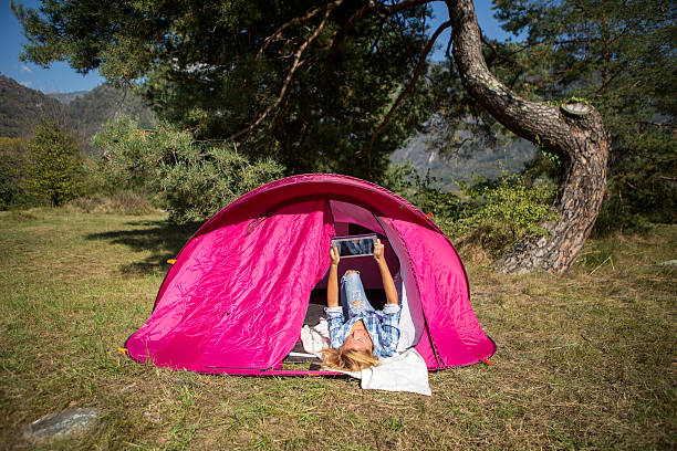 Woman in camping using digital tablet http://www.mediafire.com/convkey/839b/sq2a211uec0emhzfg.jpg women lying down grass wood stock pictures, royalty-free photos & images