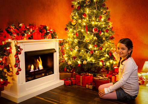 Beautiful little girl decorating Christmas tree