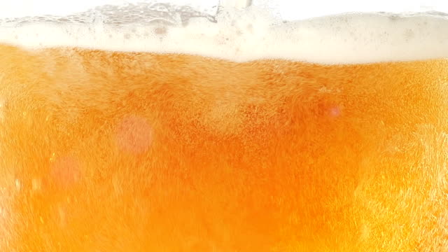 The bubbles floating up in the liquid of beer. Closeup. Slow motion