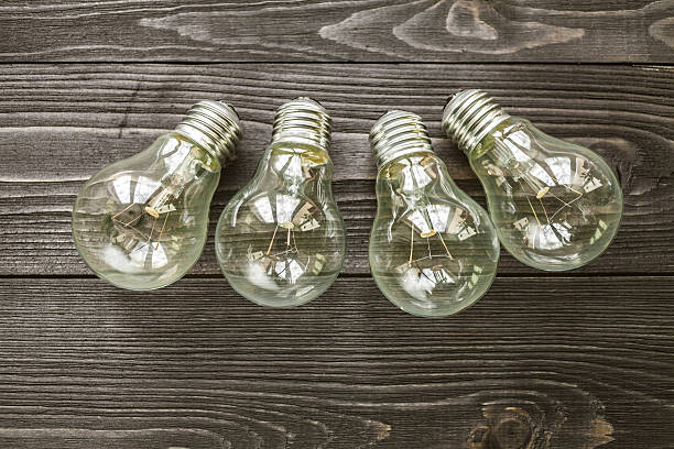 istock incandescent lamps on the wooden rustic background 517335604