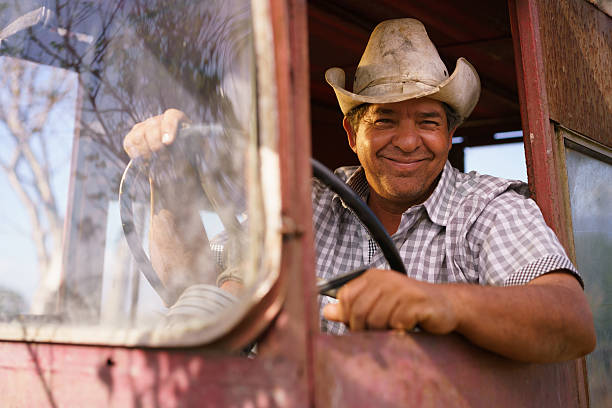 istock Portrait Happy Man Farmer Driving Tractor Looking At Camera 517335622