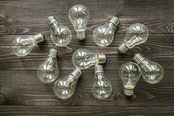 istock incandescent lamps on the wooden rustic background 517335736