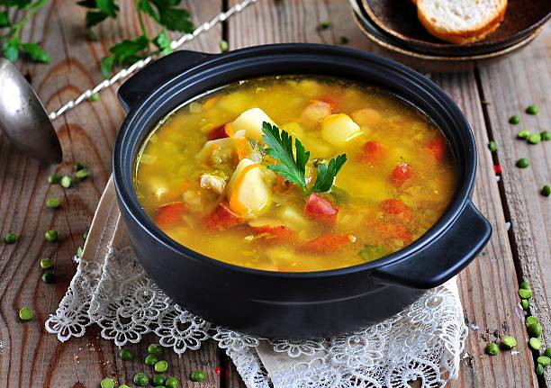 Soup of dry peas, vegetables with smoked sausage stock photo