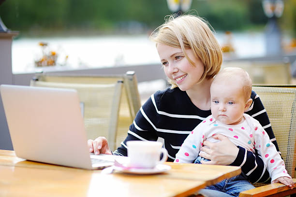 istock Young mother with her baby working or studying on laptop 517339144