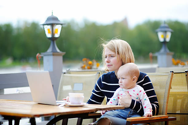 istock Young mother with her baby working or studying on laptop 517339514