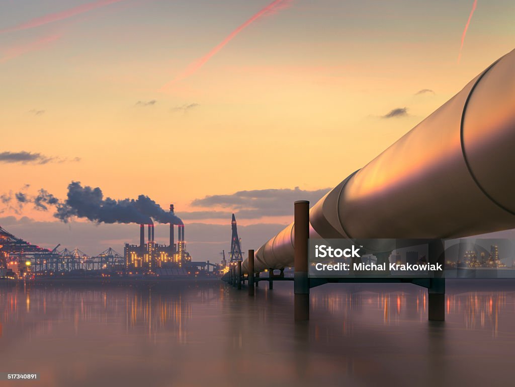 Oil pipeline in industrial district with factories at dusk Pipeline in industrial district Natural Gas Stock Photo