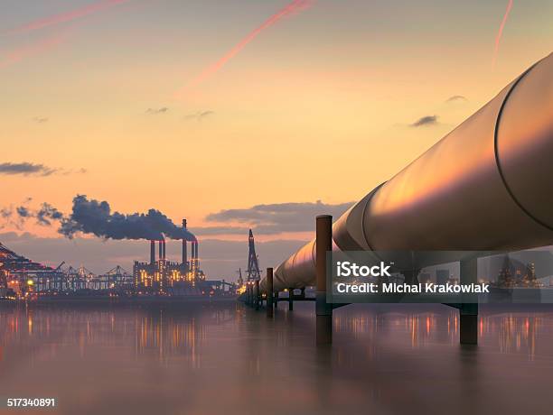 Oil Pipeline In Industrial District With Factories At Dusk Stock Photo - Download Image Now