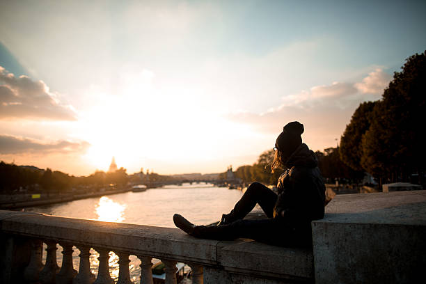 istock Woman looks at the Eiffel Tower at sunset 517341106