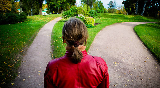 Girl in red jacket standing on the fork of two roads.