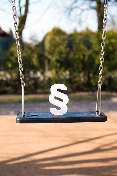 White paragraph symbol on children chain swing. White paragraph symbol on children chain swing. Family law or playground accident concept. schoolyard fight stock pictures, royalty-free photos & images