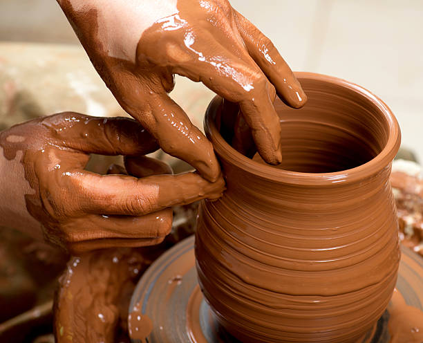 istock hands of a potter, creating an earthen jar 517343199