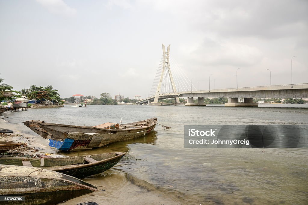 Lekki Ikoyi Bridge with fishing boat, Lagos, Nigeria The old and new are contrasted with wooden fishing boat moored on Five Cowries Creek below the Lekki Ikoyi Link Bridge, Lagos, Nigeria. Lagos - Nigeria Stock Photo