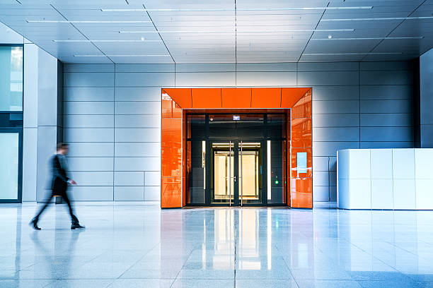 borrosa empresarios caminando en el interior de un edificio moderno - lobby architecture contemporary people fotografías e imágenes de stock