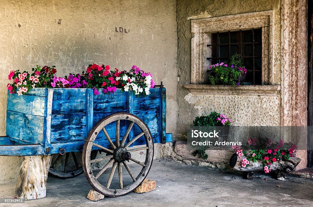 Tenno (Trento), i fiori colorati in un carrello in legno blu - Foto stock royalty-free di Ambientazione esterna