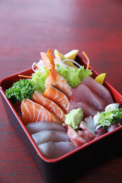 istock Sushi don , raw salmon tuna octopus on rice 517344010