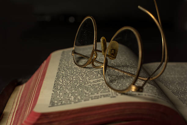 istock An old bible with antique glasses upon it- shadows 517345422