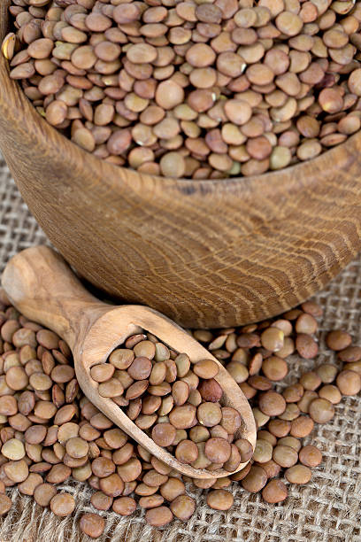 istock brown lentils in a wooden spoon 517345504