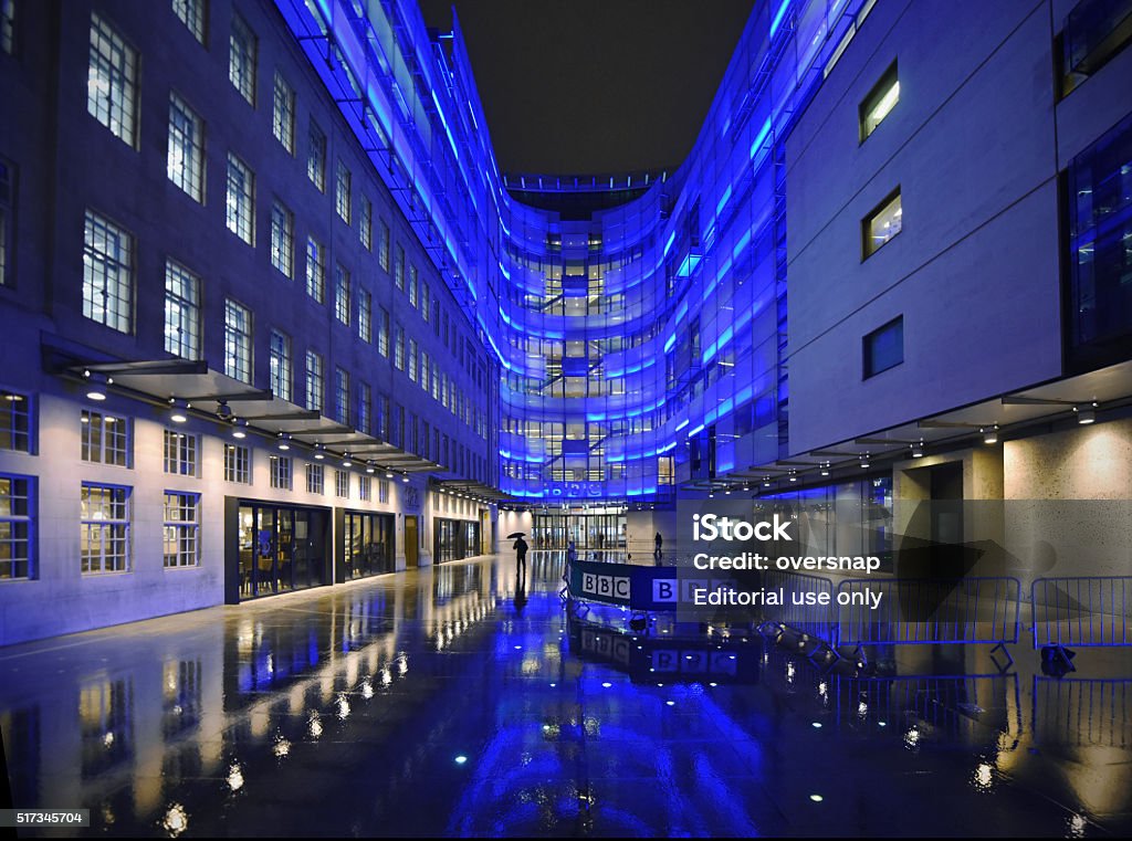 BBC HQ London, UK - March 24th 2016: BBC Broadcasting House in central London. Headquarters and offices of the British Broadcasting Corporation. Night time floodlit offices reflected in the rain - photographed from the public highway. BBC Stock Photo