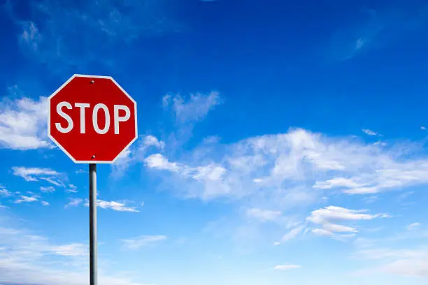 Photo of Stop Sign With Blue Sky Background and Copy Space