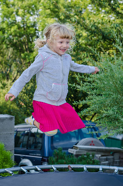 istock blond girl jumping 517346827