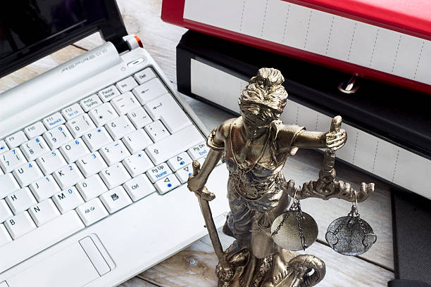 Law concept, statue, laptop and folder on wood table stock photo