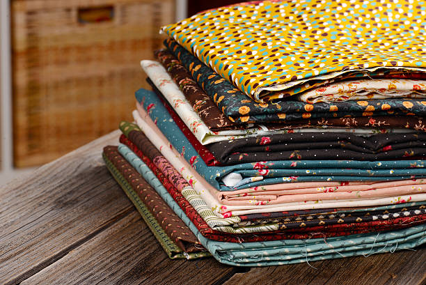 istock heap of cloth fabrics on wooden table 517347137