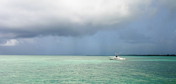 Center Console Boat anchored off a small island in the Bahamas with Storm approaching