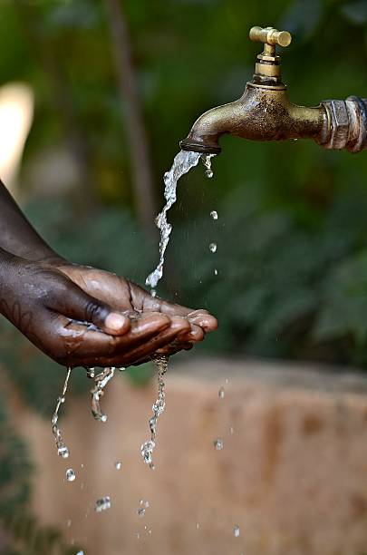 istock African Child Asking for Pouring Water from a Tap 517360957
