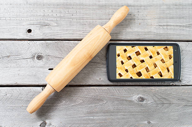 istock Rolling pin and mobiel device against old wooden background 517361523