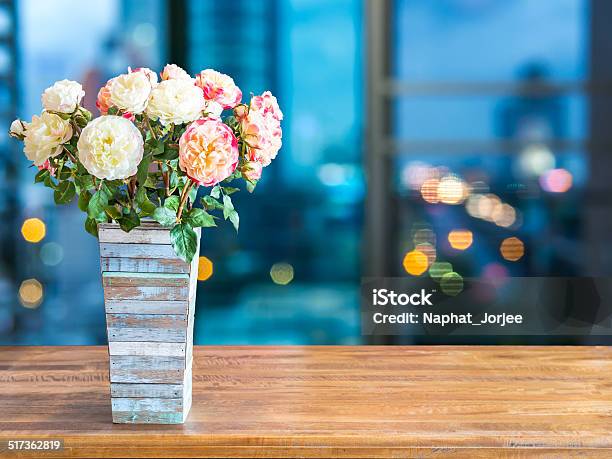 Flower Vase On Tabletop With Blurred Modern Cityscape Night Background Stock Photo - Download Image Now