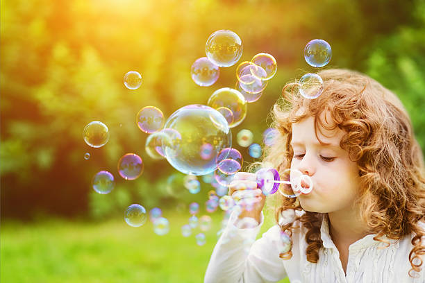 istock little girl blowing soap bubbles 517371860