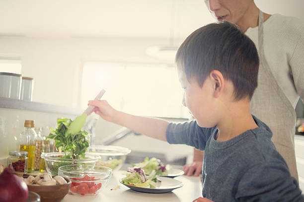 istock Son is Serve the salad together the father 517373482